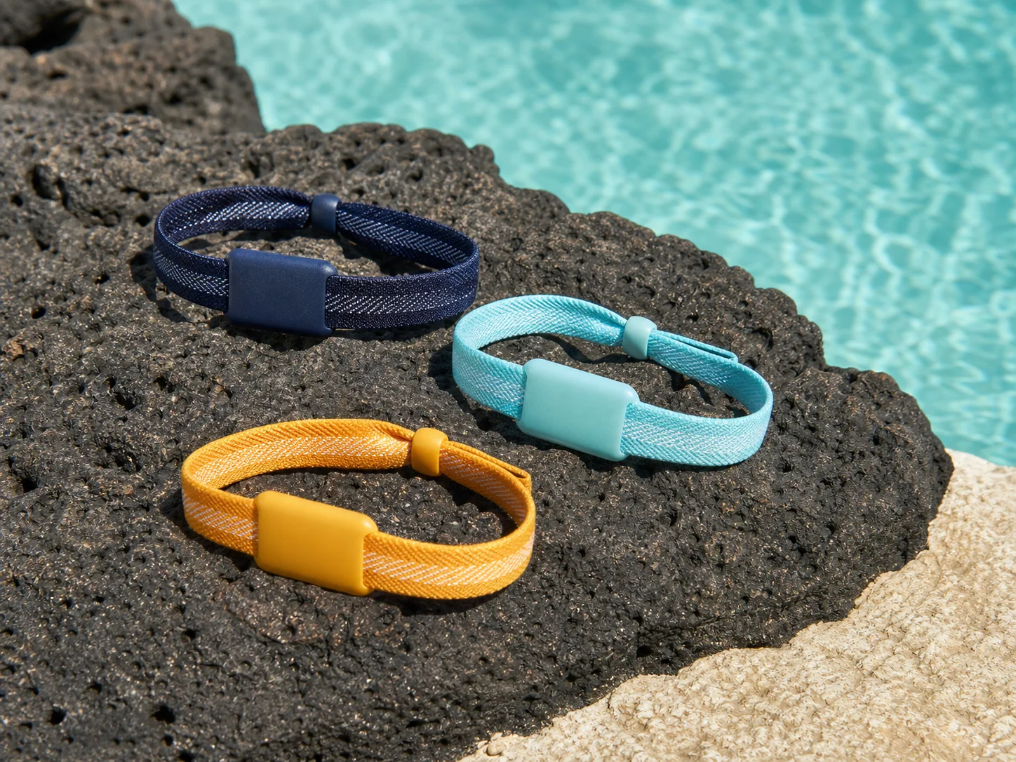 Tres pulseras RFID tejidas sin marca junto a aguas caribeñas